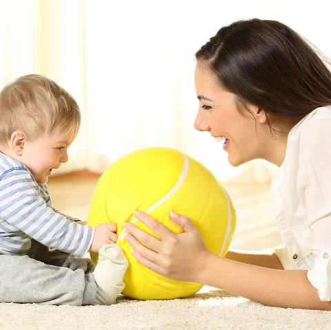mom and child playing with large ball toy
