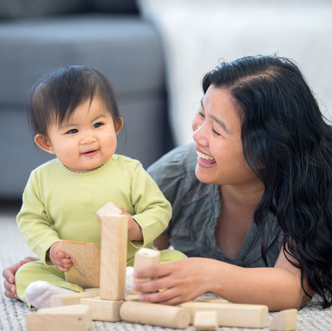 mom and child playing with blocks and smiling