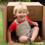 boy playing outdoors with box