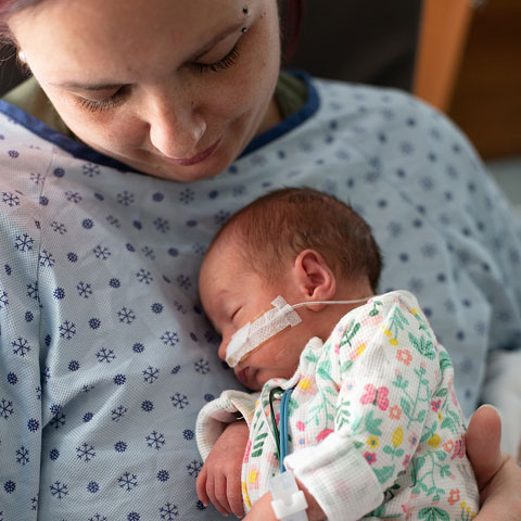 mom in hospital gown with premature infant