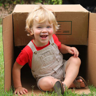 child sitting inside overturned box