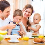 family with young children at table eating
